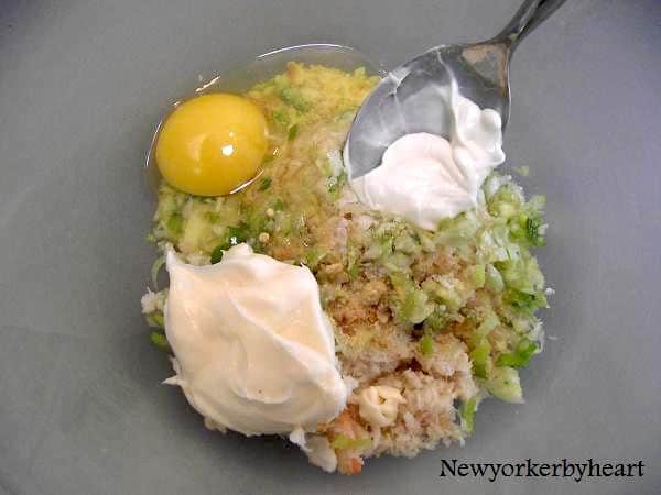 Afdryppet krabbekød blandes med forårsløg, fintknuste Tuc-kiks, æg, mayonnaise, salt og tabasco
