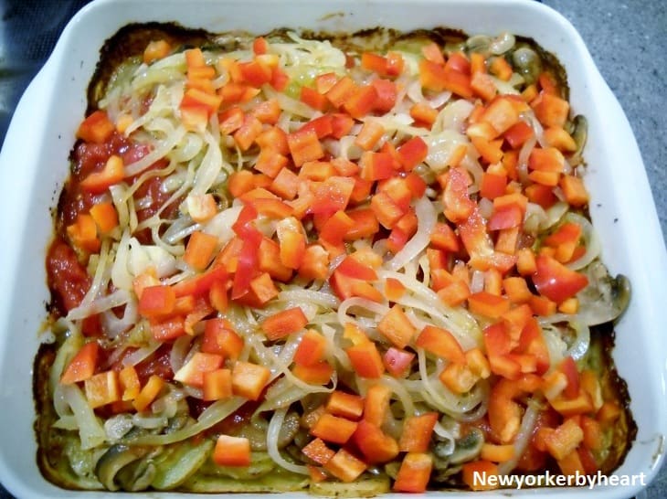 Sauteret løg og peberfrugt fordeles ovenpå